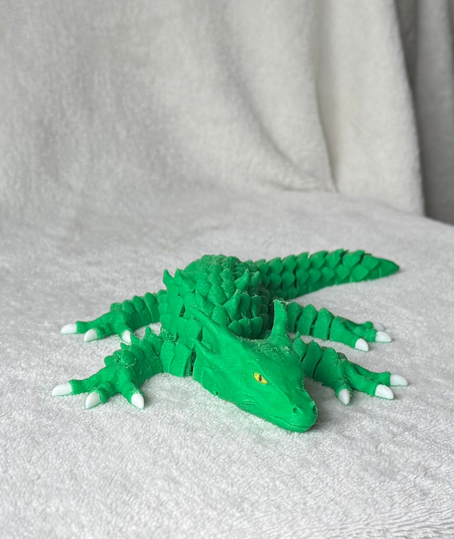 Green toy lizard on a gray surface